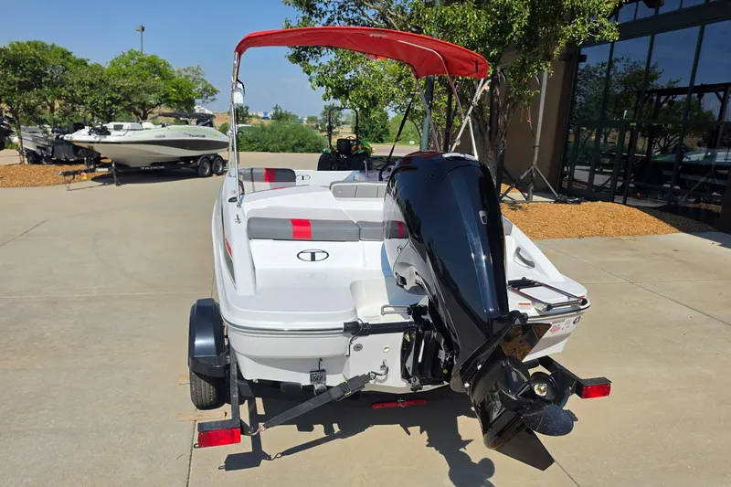 Slide: The Image of 2027 Tahoe T16 boat with red canopy and powerful outboard motor, parked outdoors. - 4