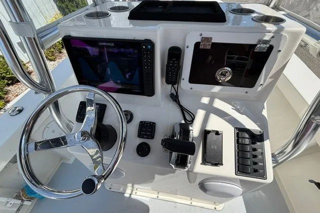 Slide: The Image of The image shows the helm of a 2023 May-Craft 20 Cape Classic boat with steering wheel and electronics. - 8