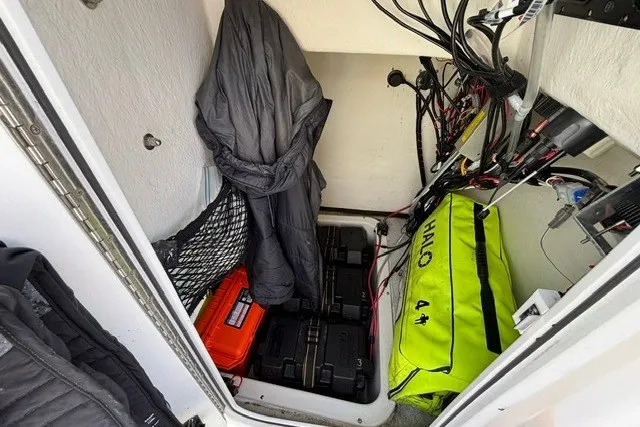 Slide: The Image of A storage compartment with batteries, cables, and a bright yellow bag. - 14