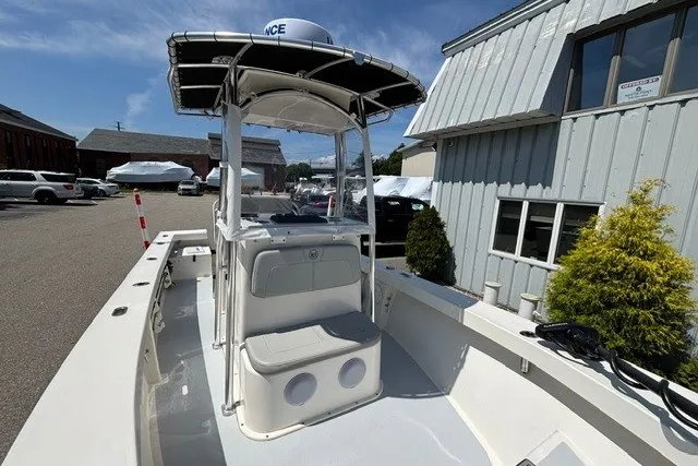 Slide: The Image of A 2023 May-Craft 20 Cape Classic with T-top and helm console, parked in a marina area. - 10