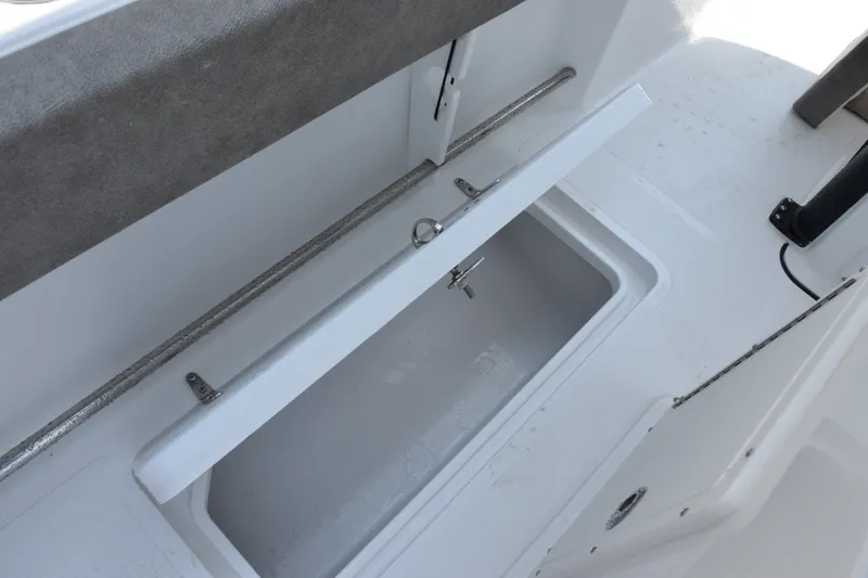 Slide: The Image of 2027 Sea Hunt Gamefish 25 boat storage compartment with open lid, showcasing interior space. - 19