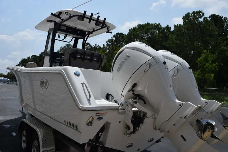 Slide: The Image of 2027 Sea Hunt Gamefish 25 boat with dual Yamaha outboard engines on a trailer. - 6