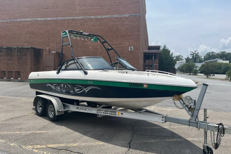 The Image of 2003 Malibu Wakesetter boat on trailer in parking lot, brick building background. - 0