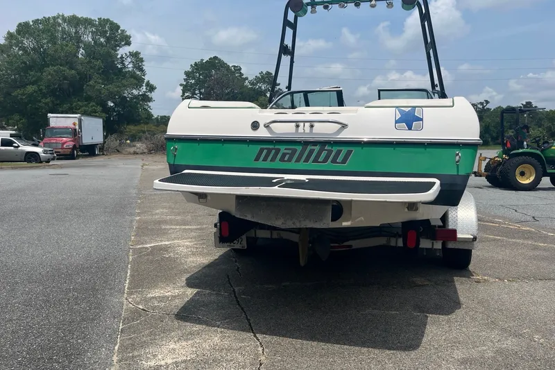 Slide: The Image of 2003 Malibu Wakesetter boat on trailer, parked outdoors on a sunny day. - 5