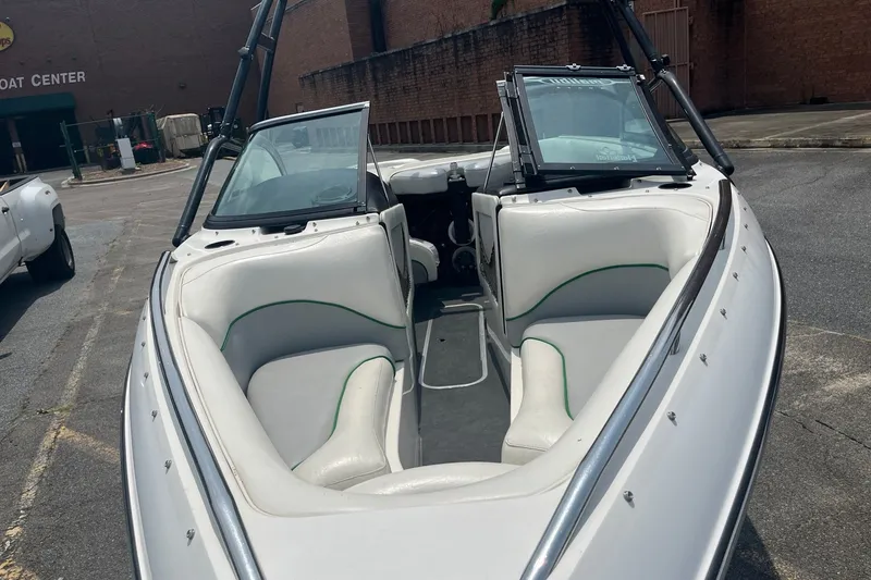 Slide: The Image of 2003 Malibu Wakesetter boat with white interior, parked near a building. - 10