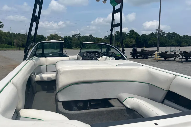 Slide: The Image of 2003 Malibu Wakesetter boat interior with white seating, parked outdoors under a cloudy sky. - 9