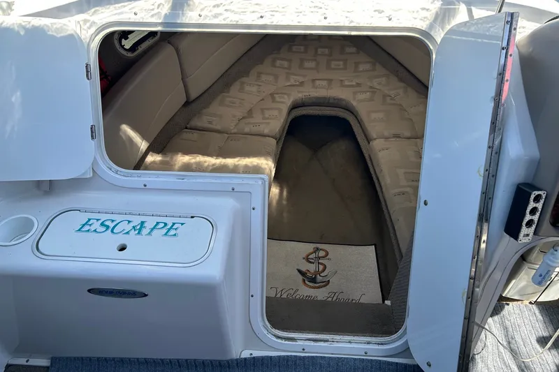 Slide: The Image of 2002 Four Winns 225 Sundowner cabin interior with "Escape" label and welcome mat. - 13
