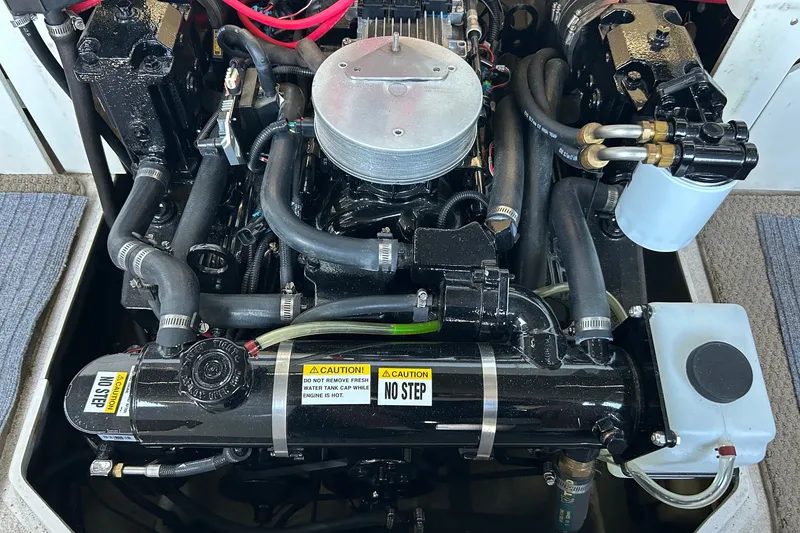 Slide: The Image of 2002 Four Winns 225 Sundowner engine compartment with visible components and caution labels. - 16