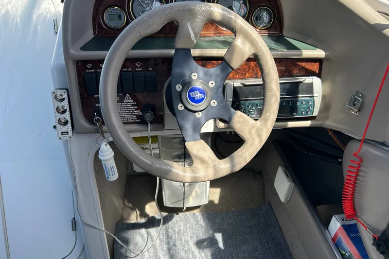 Slide: The Image of Steering wheel and dashboard of a 2002 Four Winns 225 Sundowner boat. - 8