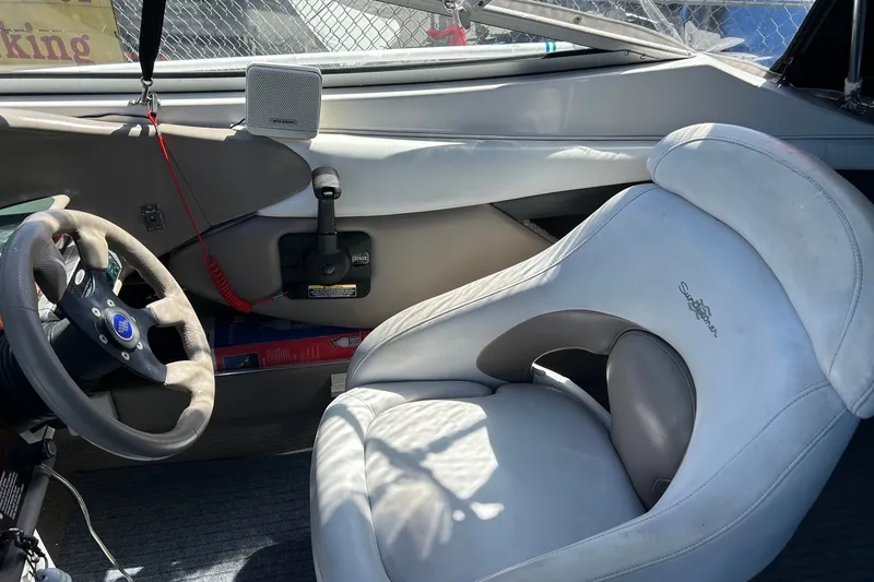 Slide: The Image of Interior of 2002 Four Winns 225 Sundowner boat with steering wheel and cushioned seat. - 7