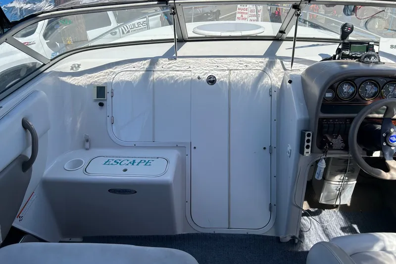 Slide: The Image of Interior of a 2002 Four Winns 225 Sundowner boat, featuring steering wheel and dashboard controls. - 6