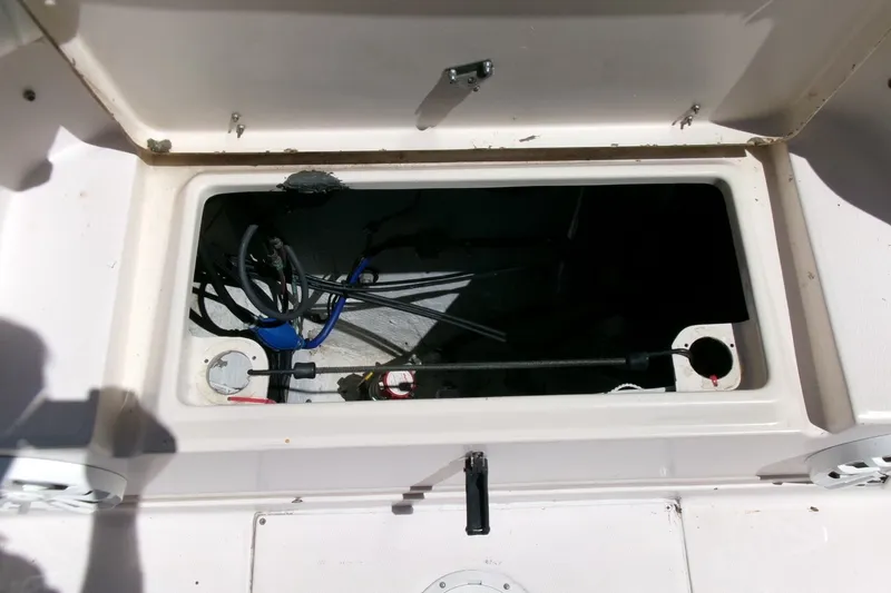 Slide: The Image of Open storage compartment on a 2001 Grady-White Gulfstream 232 boat, showing internal wiring. - 24