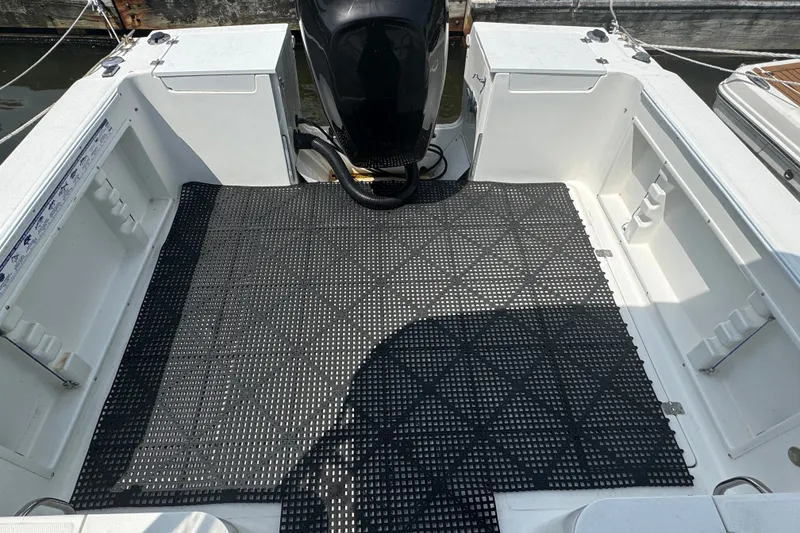 Slide: The Image of 2002 Wellcraft 220 Coastal boat deck with black non-slip matting and outboard motor. - 3