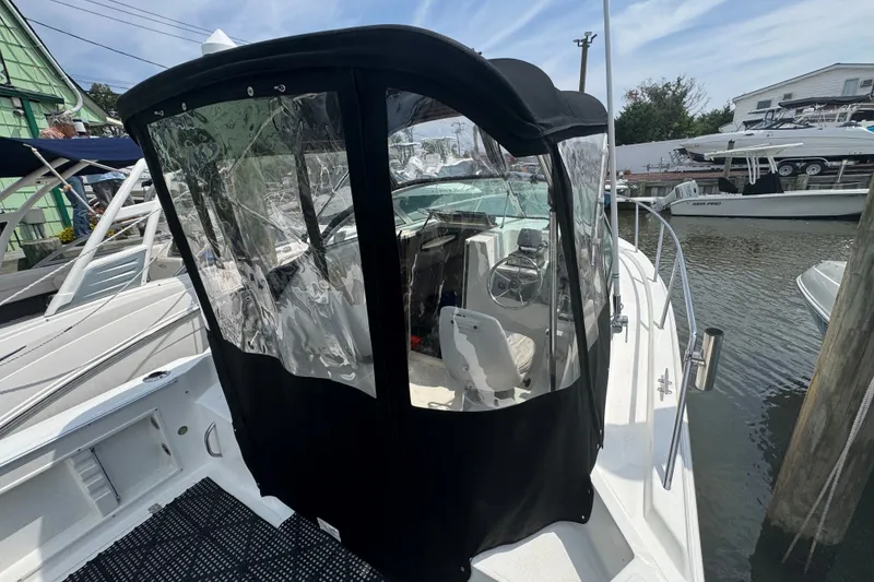 Slide: The Image of 2002 Wellcraft 220 Coastal boat with enclosed cockpit, docked at a marina. - 16