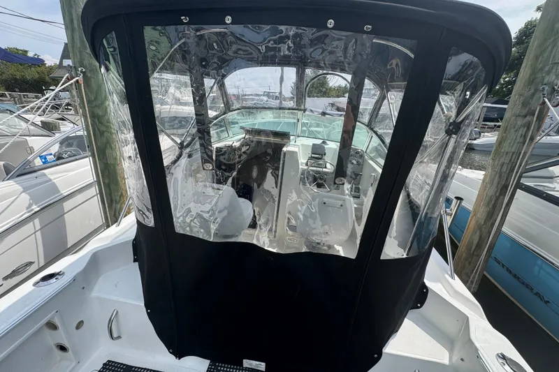 Slide: The Image of 2002 Wellcraft 220 Coastal boat with clear cockpit enclosure at marina. - 14