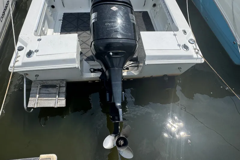 Slide: The Image of 2002 Wellcraft 220 Coastal boat with outboard motor docked in water. - 2