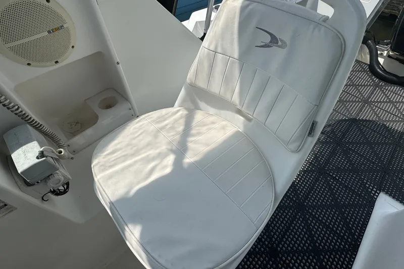 Slide: The Image of White cushioned seat on a 2002 Wellcraft 220 Coastal boat, featuring a speaker and cup holder. - 12