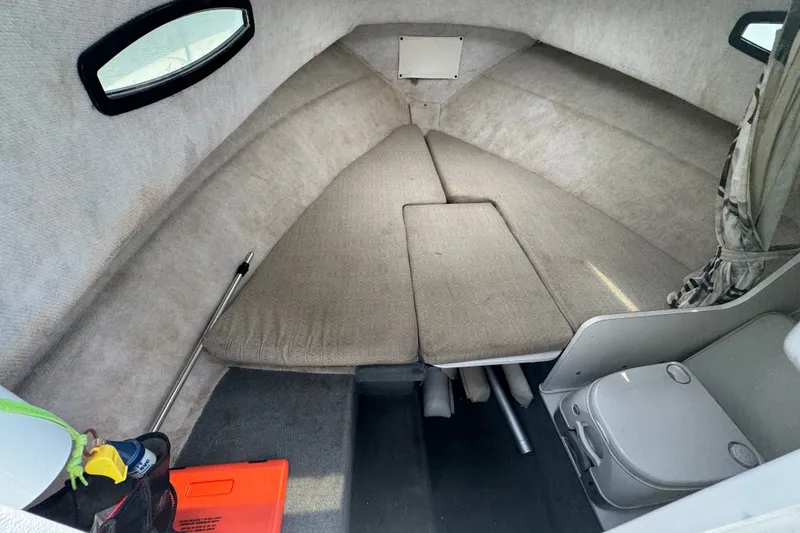 Slide: The Image of Interior cabin of 2002 Wellcraft 220 Coastal boat, featuring cushioned seating and storage. - 18