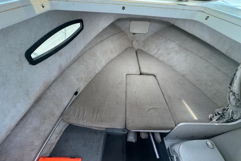 Slide: The Image of Interior cabin of 2002 Wellcraft 220 Coastal boat, featuring cushioned seating and compact design. - 21