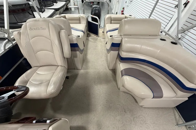 Slide: The Image of 2012 South Bay 522 SL pontoon boat interior with beige and blue seating. - 14
