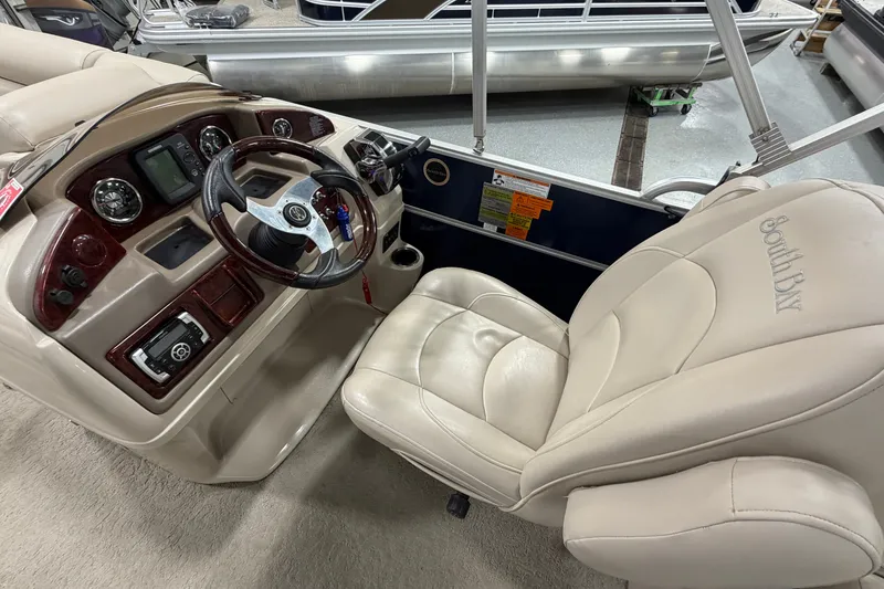 Slide: The Image of Interior of a 2012 South Bay 522 SL boat with steering wheel and captain's chair. - 21