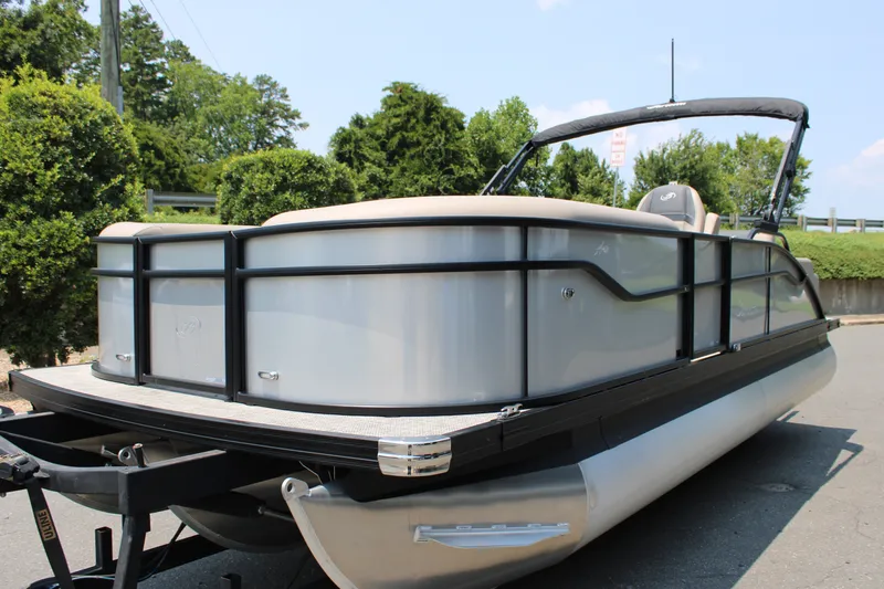Slide: The Image of 2027 Barletta ARIA 22UC pontoon boat on trailer, surrounded by greenery. - 7