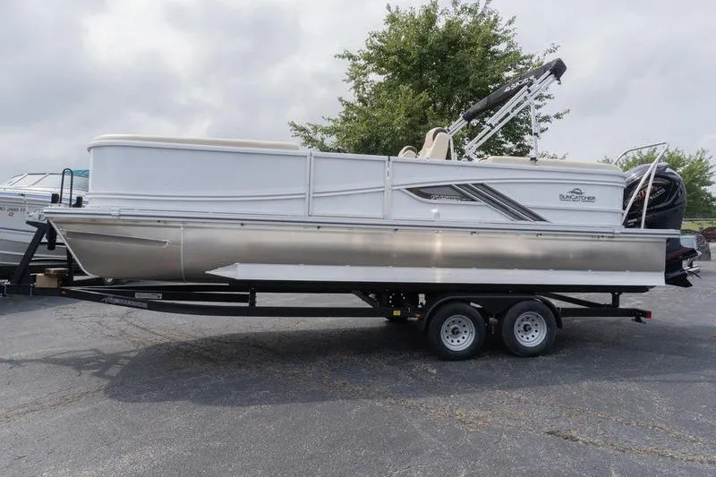 Slide: The Image of 2026 SunCatcher Fusion 324RC pontoon boat on trailer, parked outdoors. - 4