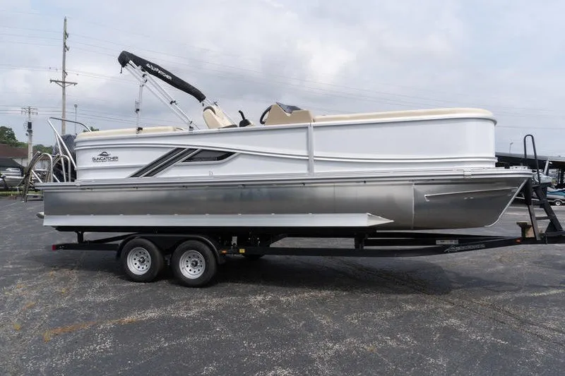 Slide: The Image of 2026 SunCatcher Fusion 324RC pontoon boat on trailer, parked outdoors. - 2