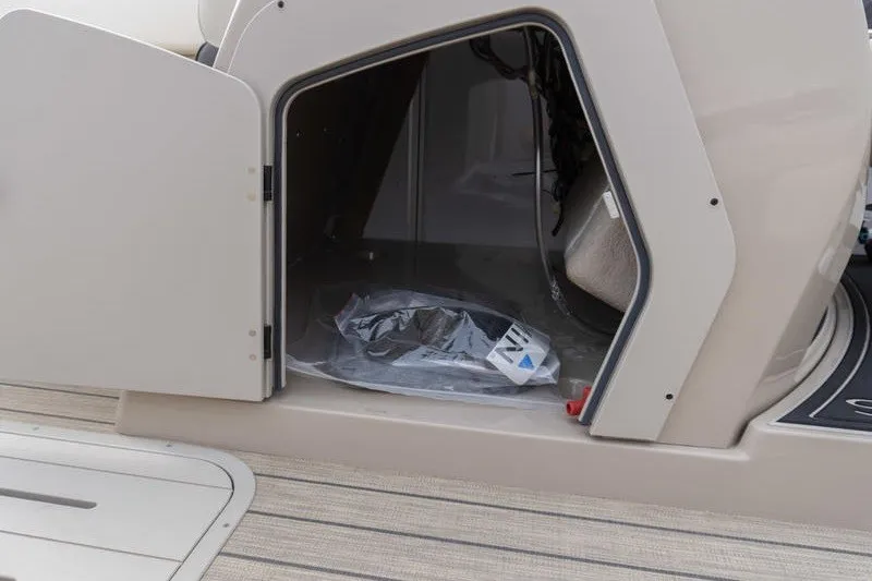Slide: The Image of Open storage compartment on 2026 SunCatcher Fusion 324RC boat, showcasing interior space. - 16