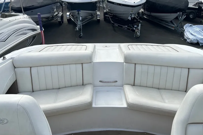Slide: The Image of Interior of a 2008 Cobalt 200 boat with white seating and docked boats in background. - 16
