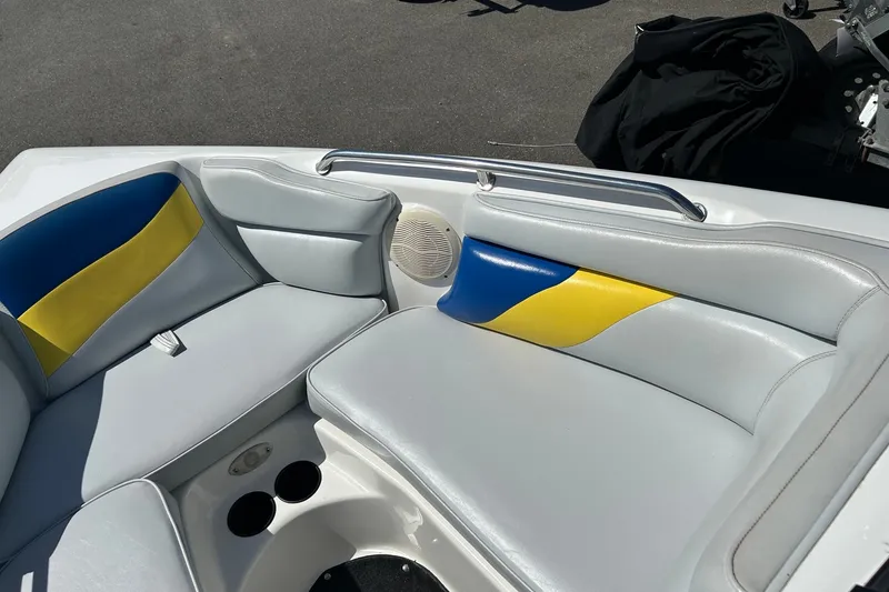 Slide: The Image of 2001 Tige 22i boat interior with blue and yellow cushioned seating. - 13
