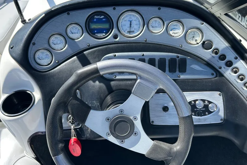 Slide: The Image of Steering wheel and dashboard of a 2001 Tige 22i boat with gauges and controls. - 4