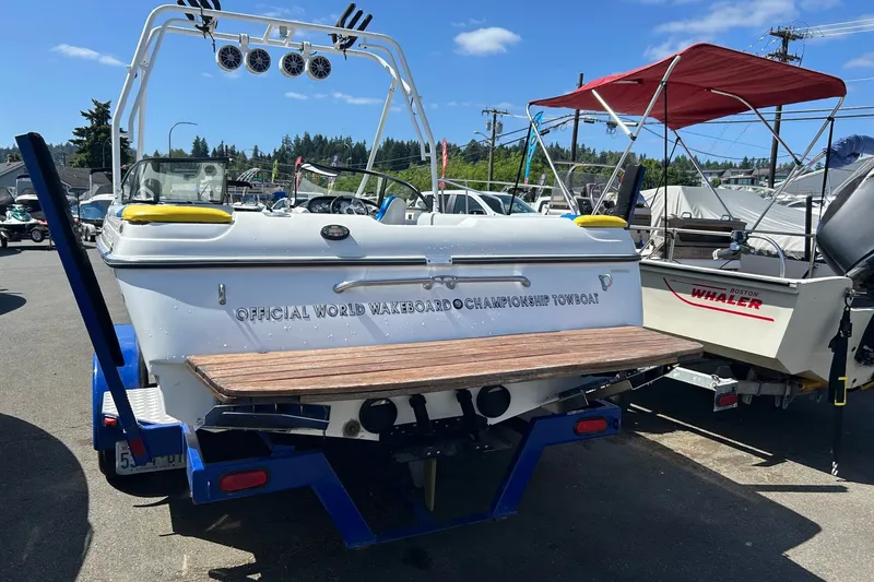 Slide: The Image of 2001 Tige 22i wakeboard boat with tower and speakers, parked in a marina. - 3