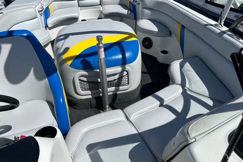 Slide: The Image of Interior of a 2001 Tige 22i boat with white, blue, and yellow seating. - 11