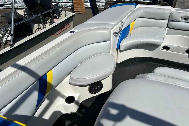 Slide: The Image of 2001 Tige 22i boat interior with white and blue seating, cup holders, and speaker. - 19