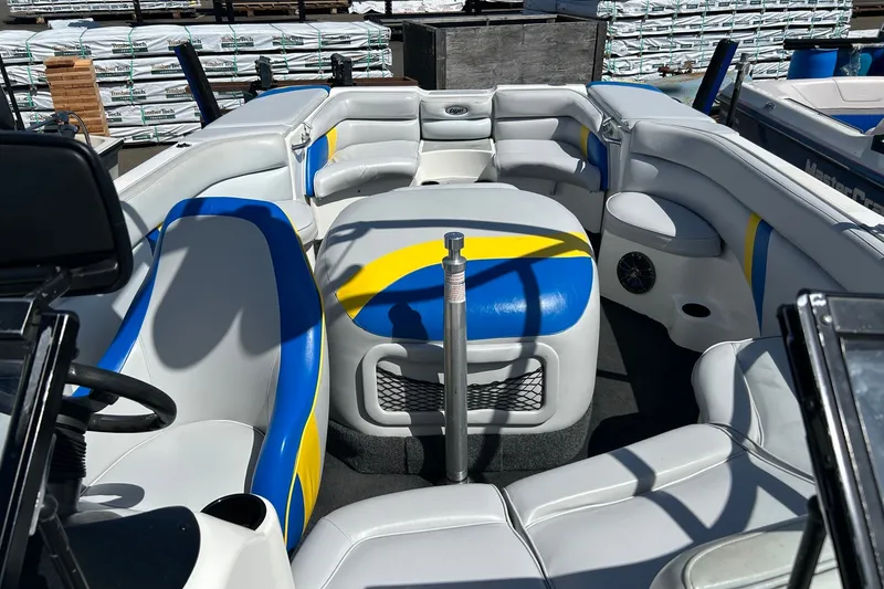 Slide: The Image of 2001 Tige 22i boat interior with blue and yellow seating, showcasing spacious design. - 8
