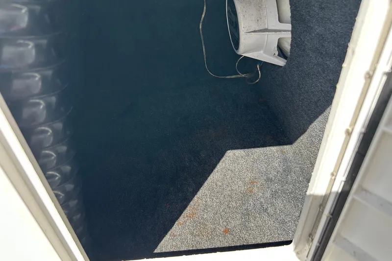 Slide: The Image of Carpeted storage compartment in a 2001 Tige 22i boat, featuring a speaker. - 18