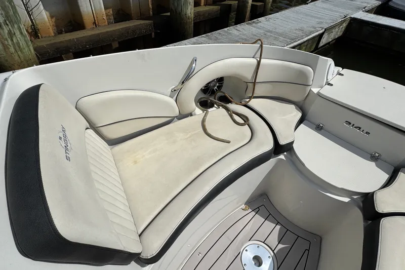 Slide: The Image of Interior of a 2021 Stingray 214 LR boat with cushioned seating and docked rope. - 16