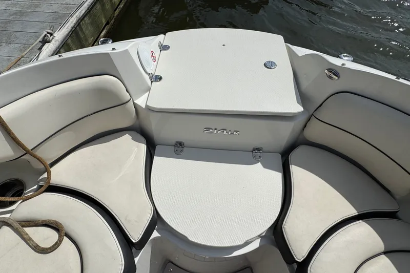Slide: The Image of 2021 Stingray 214 LR boat interior with cushioned seating and storage compartment. - 18