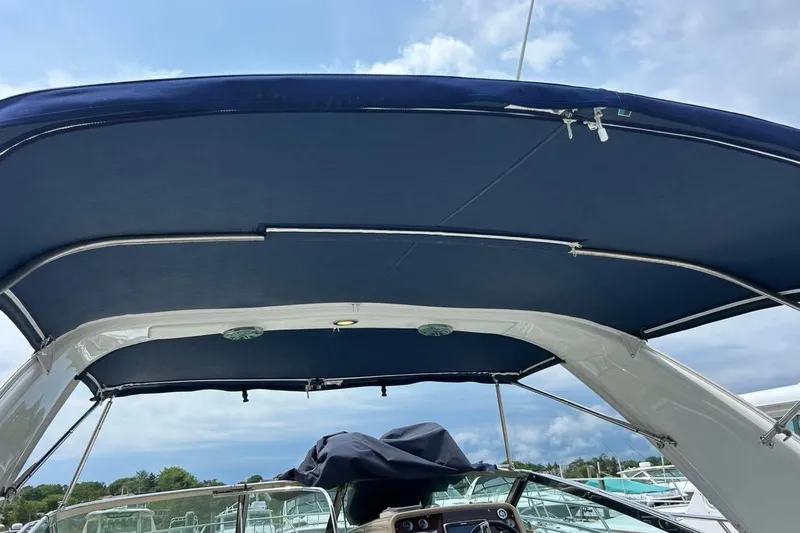 Slide: The Image of 2016 Formula 31 Performance Cruiser with blue canopy, docked under a cloudy sky. - 16
