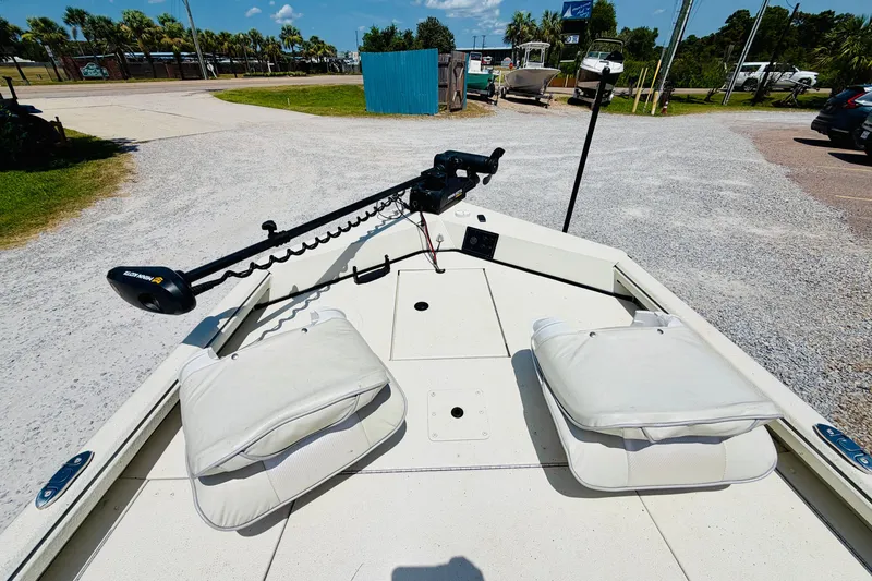 Slide: The Image of 2021 Ranger RB200 boat deck with cushioned seats and trolling motor, parked outdoors. - 11