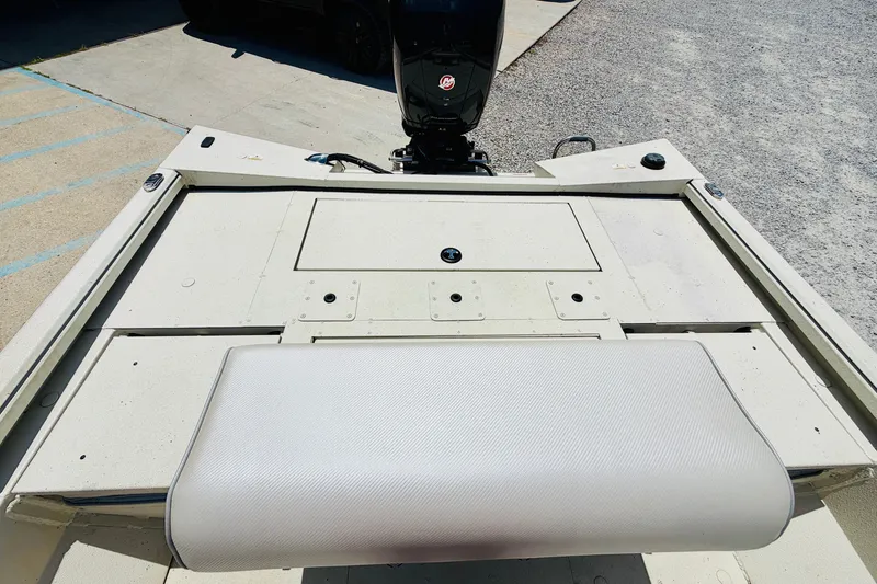 Slide: The Image of 2021 Ranger RB200 boat deck with motor, featuring a cushioned seat and storage compartments. - 18