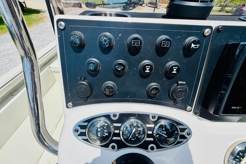 Slide: The Image of Control panel of a 2021 Ranger RB200 boat with various switches and gauges. - 15