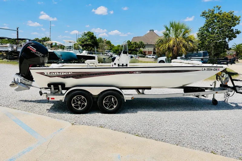 Slide: The Image of 2021 Ranger RB200 boat on trailer, parked outdoors under a clear blue sky. - 5
