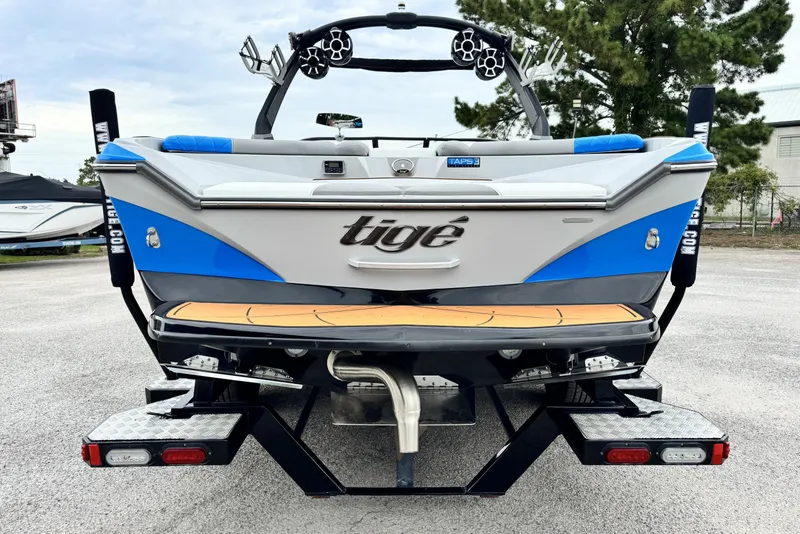 Slide: The Image of 2017 Tigé R23 boat, rear view, featuring blue and white design with wakeboard tower. - 5