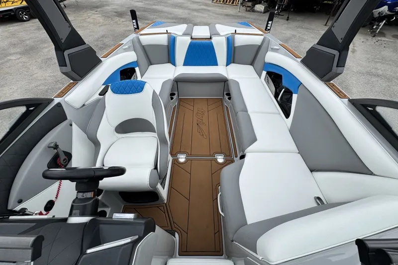 Slide: The Image of 2017 Tigé R23 boat interior with white and blue seating, brown flooring, and modern helm. - 15