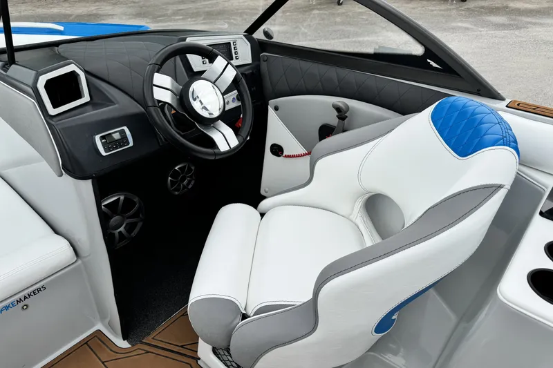Slide: The Image of Interior of a 2017 Tigé R23 boat featuring a sleek steering wheel and modern seating. - 11