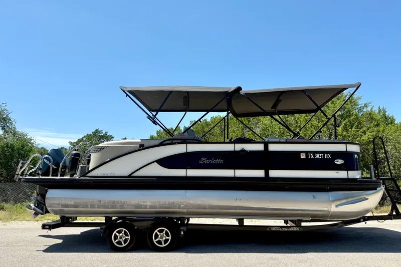 Slide: The Image of 2019 Barletta L23QC SS pontoon boat on trailer under clear blue sky. - 15