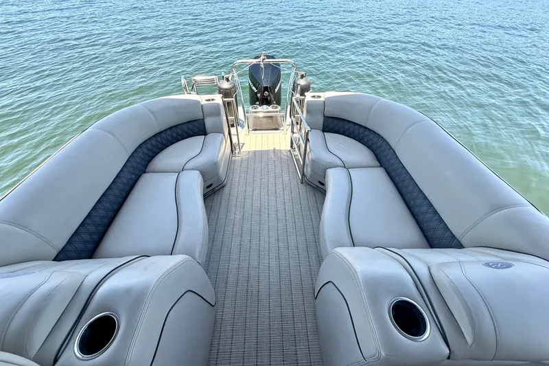 Slide: The Image of Luxurious seating on a 2019 Barletta L23QC SS pontoon boat, overlooking serene water. - 18