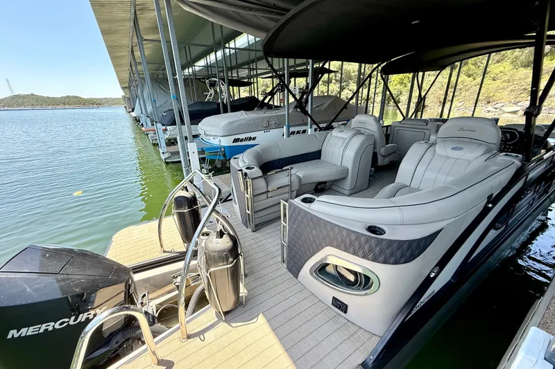 Slide: The Image of 2019 Barletta L23QC SS pontoon boat docked, featuring luxurious seating and Mercury engine. - 35